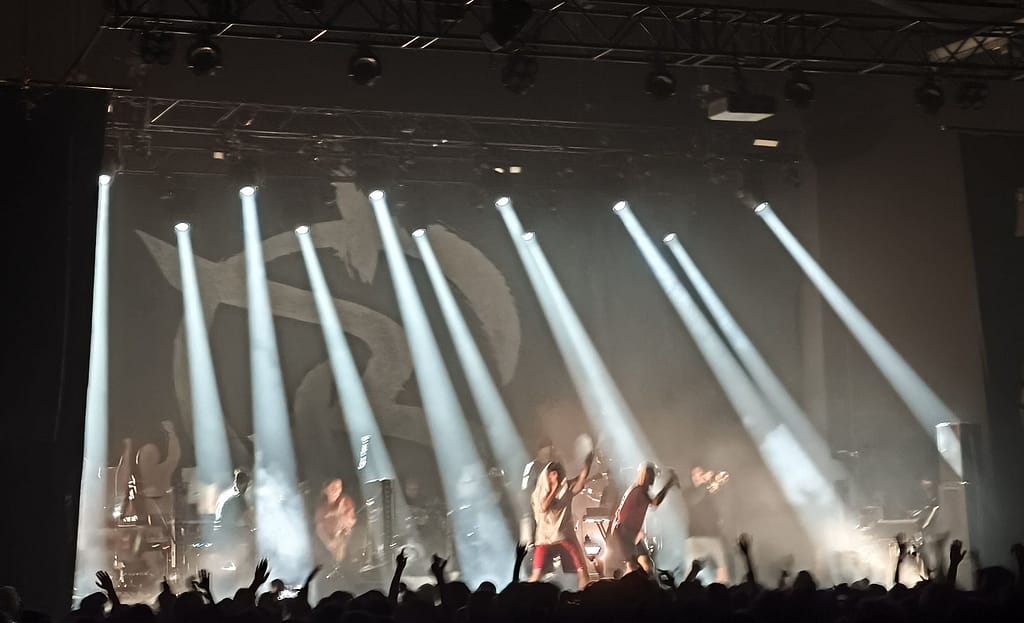 Irie Révoltés live im Schlachthof Wiesbaden, Foto von der Bühne mit mehreren Spots, die von hinten auf die Front Row leuchten