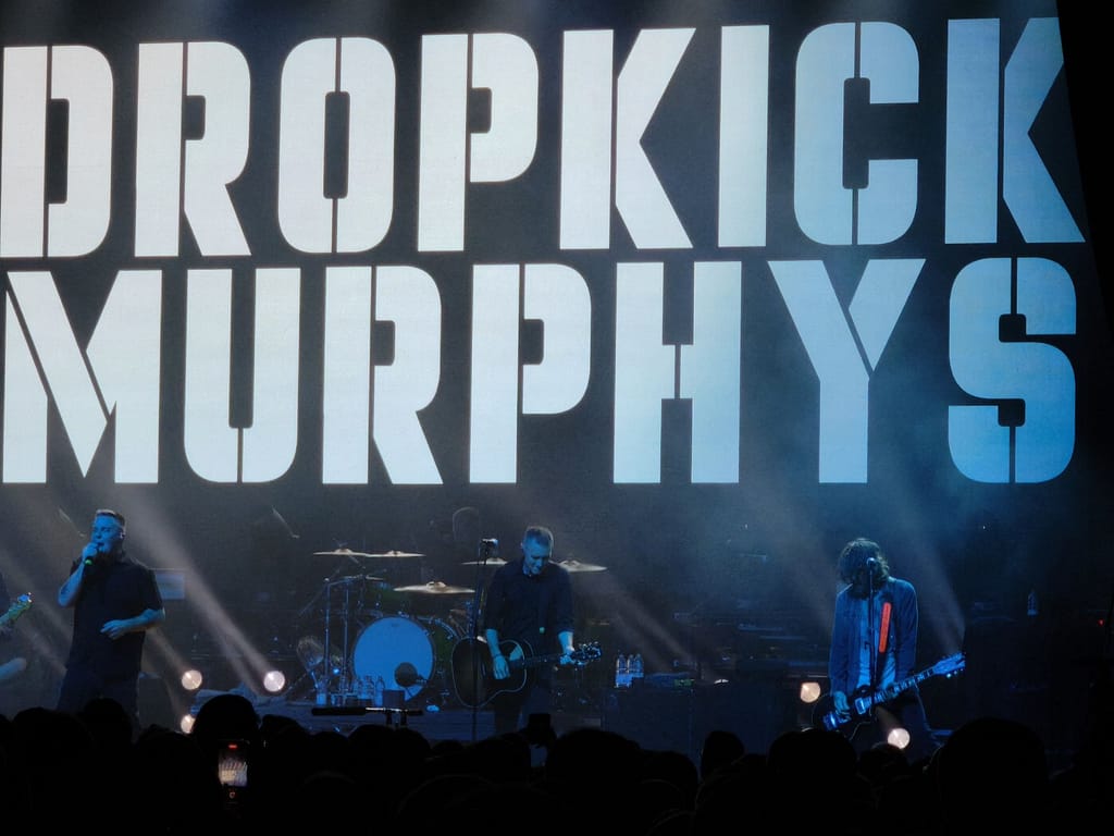 Die Dropkick Murphys auf der Bühne vor einem großen Schriftzug des Bandnamens