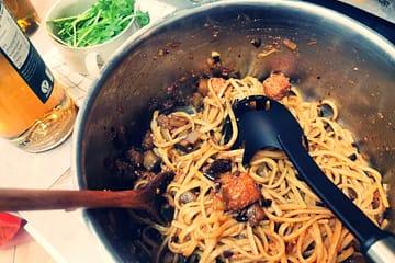 Ein großer Edelstahltopf mit den nudeln gemäß Rezept, daneben eine Flasche mit Balsamico Bianco und eine Schale Rucola