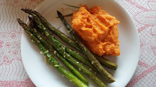 grilled asparagus with sweet potato mash on a white table
